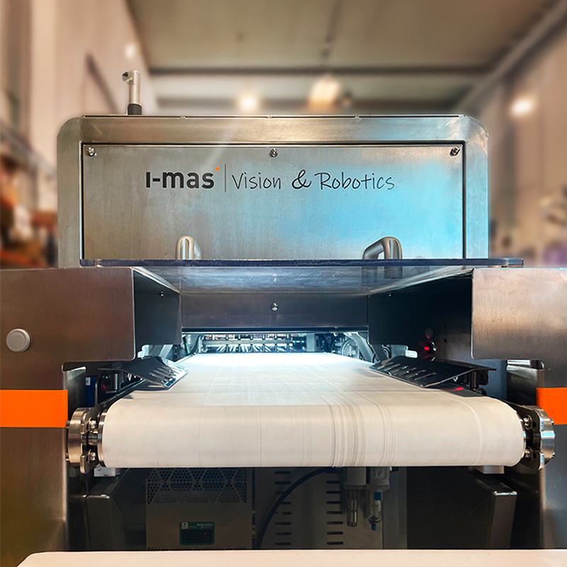 Equipo i-mas Vision & Robotics con iluminación de inspección sobre una cinta transportadora