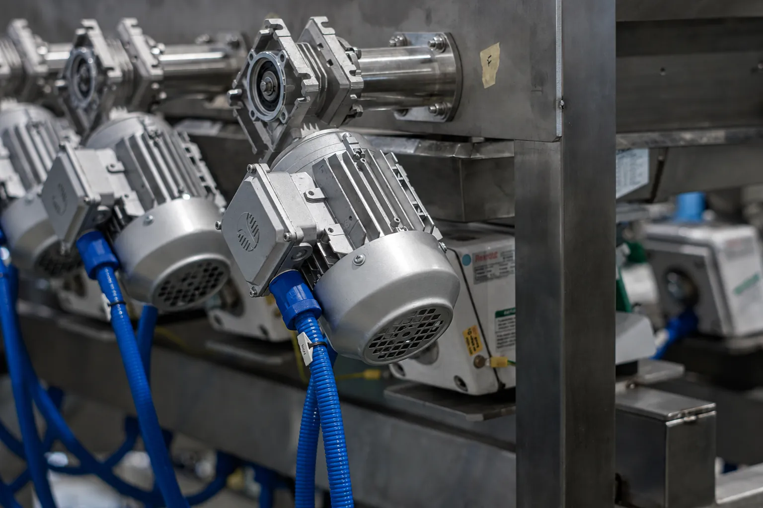 Motorreductores en fila sobre el bastidor de acero inoxidable de una línea automatizada