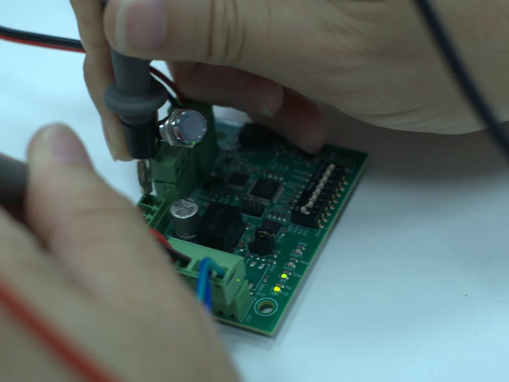 Ingeniero de i-mas Electronics comprobando una PCB con las puntas del multímetro