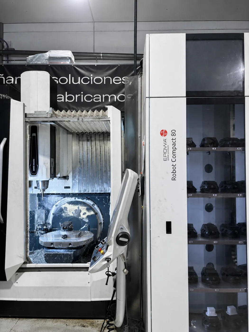 Centro de mecanizado de cinco ejes DMG MORI con la mesa basculante y el robot de carga Erowa Robot Compact 80 con sus palets