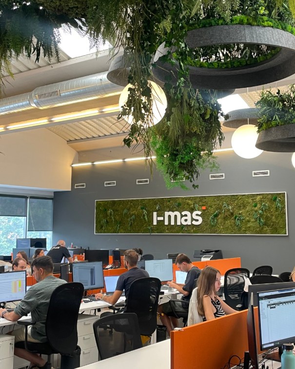 Vista general de la oficina de i-mas con el logotipo vegetal en la pared
