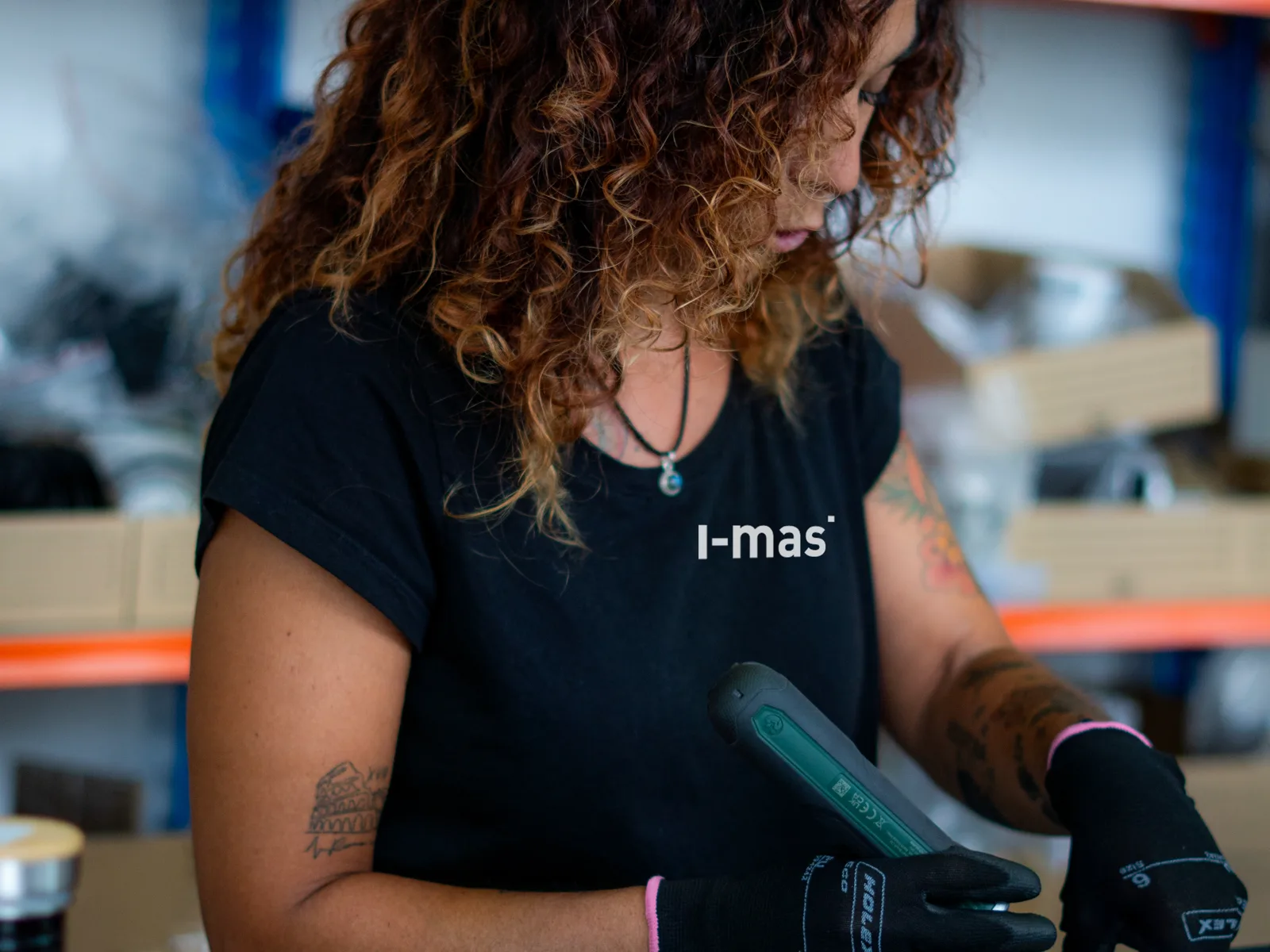 A worker at the i-mas assembly station, with the units from the series in front of them.