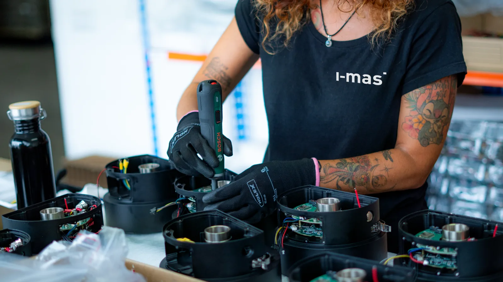 An i-mas technician assembling electronics for a batch of equipment