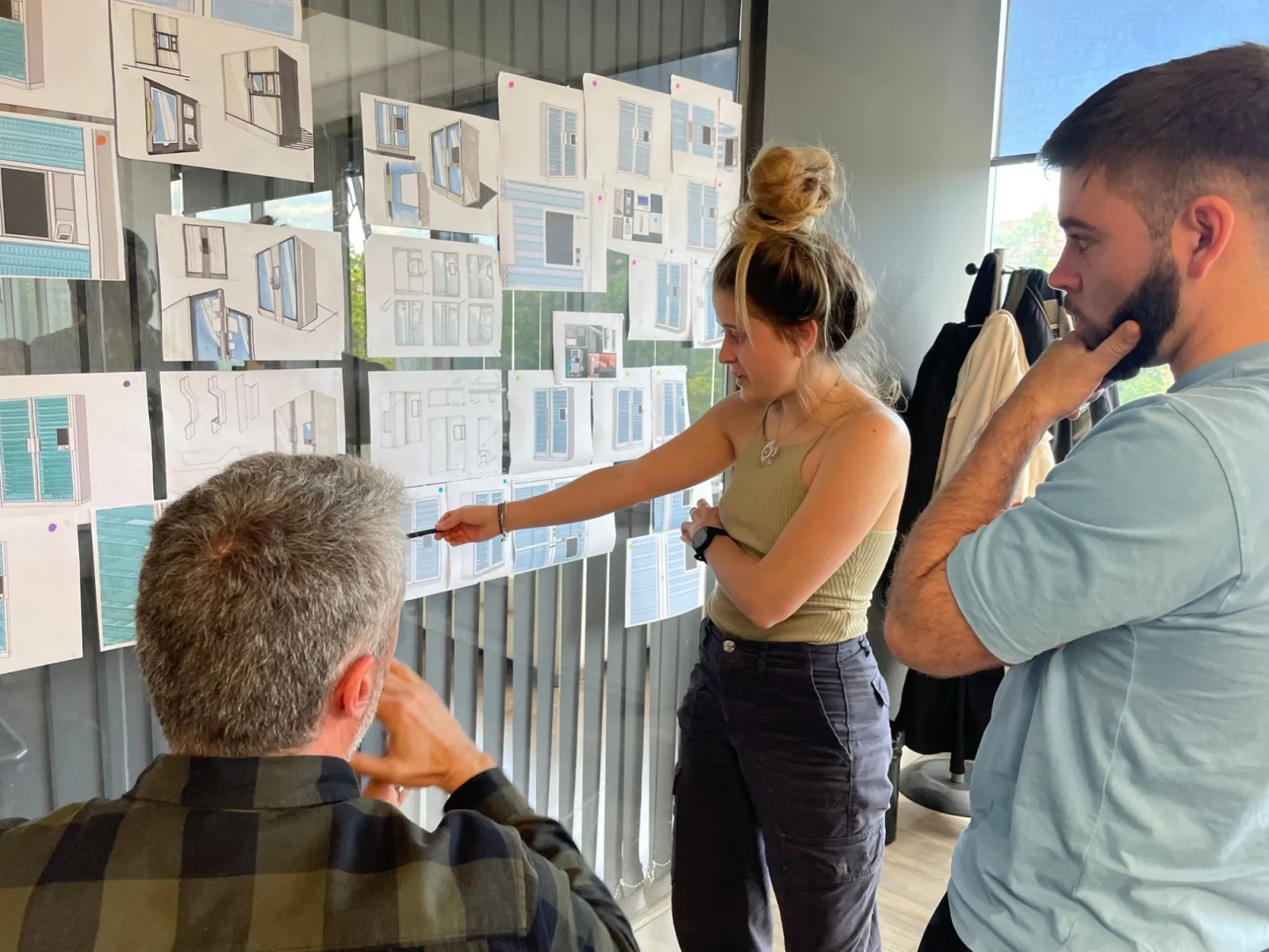 El equipo de i-mas revisa los bocetos de un producto en la pared del estudio